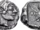 Coinage began to be adopted in Greece in the mid-6th century BC, beginning with Aegina, which minted distinctive "turtle coins" (above), before moving to other cities including Athens (below), whose coins were exported throughout the Greek world.