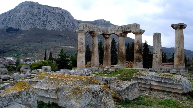 Ruins of the Temple of Apollo within the polis of Ancient Corinth, built c. 540 BC, with the Acrocorinth (the city's acropolis)